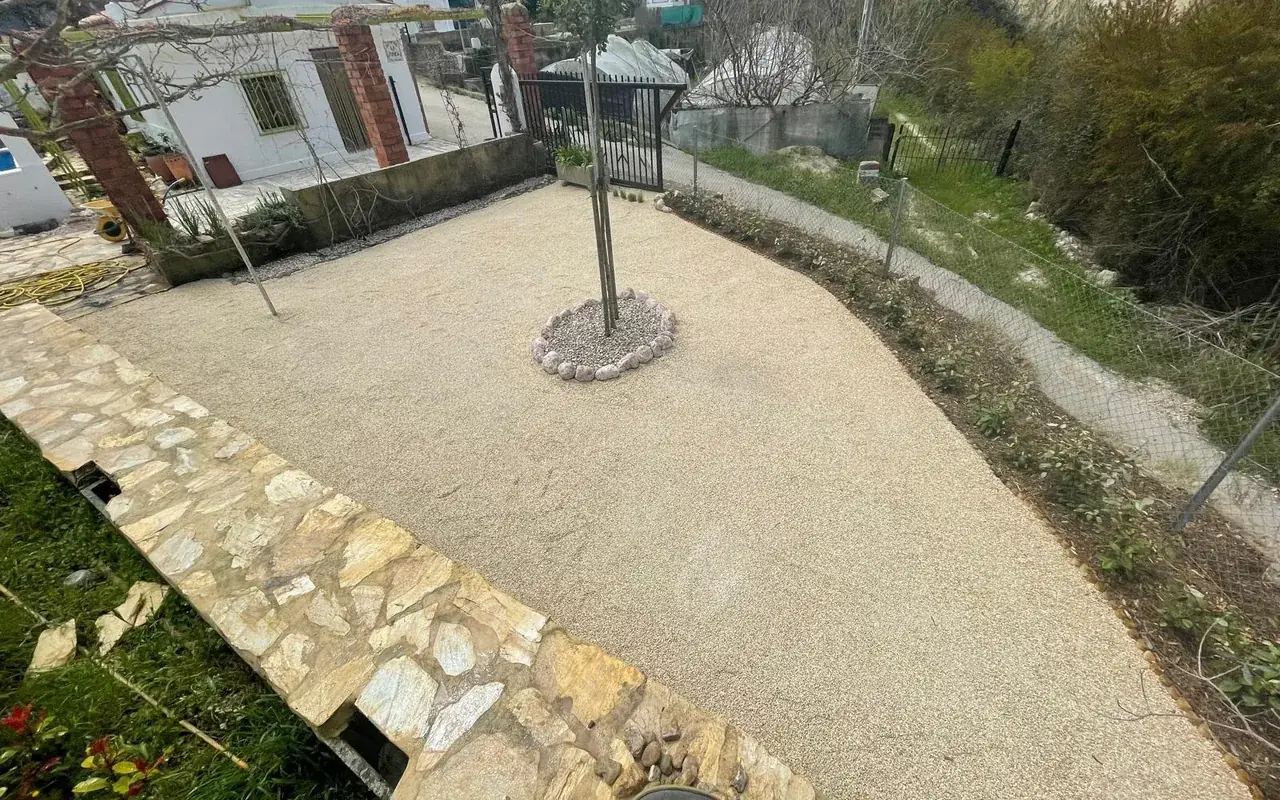 Patio de albero con bancal de piedra natural y arbolado